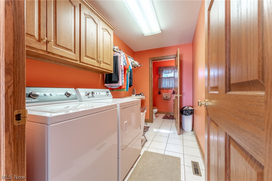 20 Reedsburg Road Wooster, OH 44691 - Photo 32 of 42 Laundry room with cabinets, washer and clothes dryer, and light tile floors