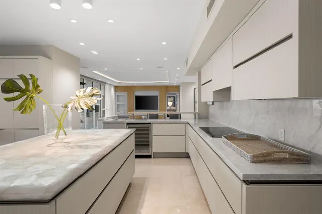 a kitchen with stainless steel appliances kitchen island granite countertop a refrigerator a stove a sink and a blue with wooden floor