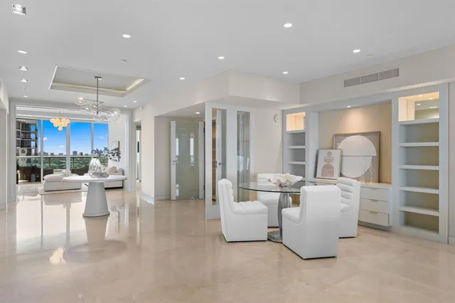 a living room with furniture a flat screen tv and kitchen view