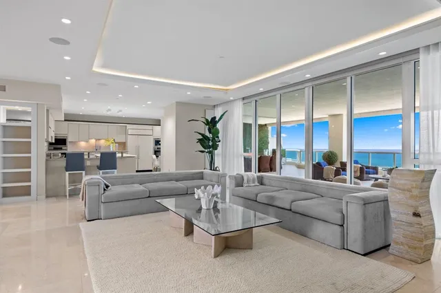 a kitchen with stainless steel appliances kitchen island granite countertop a table chairs and a refrigerator