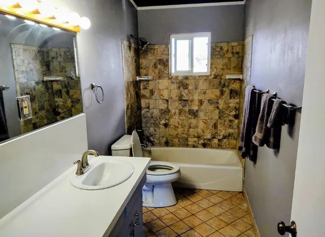 a bathroom with a sink toilet and shower