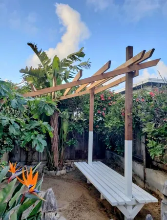 a backyard of a house with table and chairs potted plants