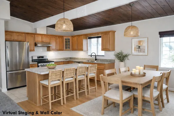 a kitchen with a dining table chairs stainless steel appliances and cabinets