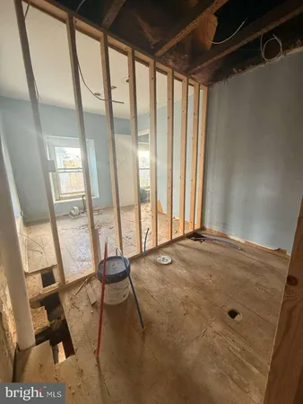 a view of an empty room with wooden floor and furniture