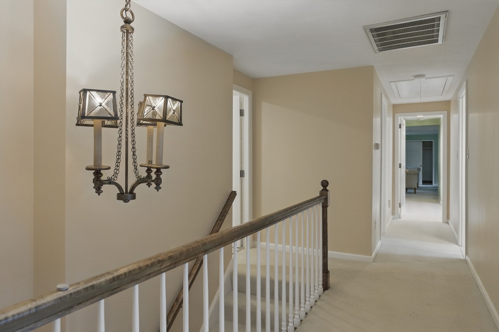 14 Harvard Drive Bedford, MA 01730 - Photo 25 of 40 a view of a hallway with wooden floor and staircase