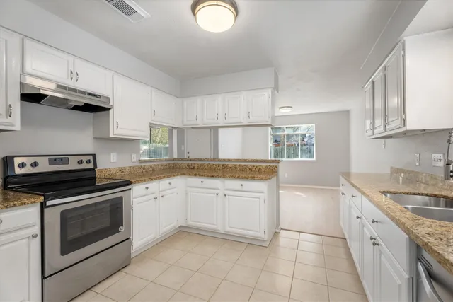 a kitchen with granite countertop cabinets stainless steel appliances and a sink