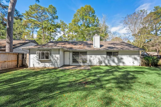 a front view of a house with a garden and trees