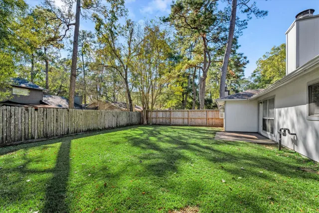 a view of a backyard with a barn and large trees