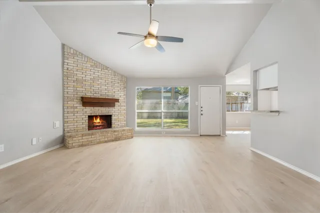 an empty room with windows and fireplace