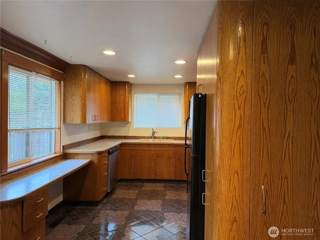 a large kitchen with stainless steel appliances a sink and cabinets