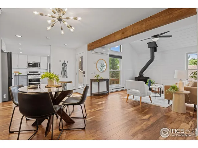 a living room with furniture kitchen view and a wooden floor