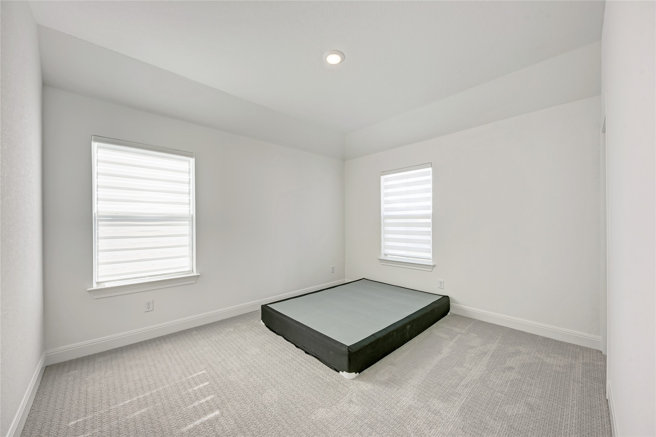 316 Regatta Trail Leander, TX 78641 - Photo 31 of 39 Room featuring two windows with horizontal blinds, light-colored carpeting, a recessed ceiling light, and crisp white walls