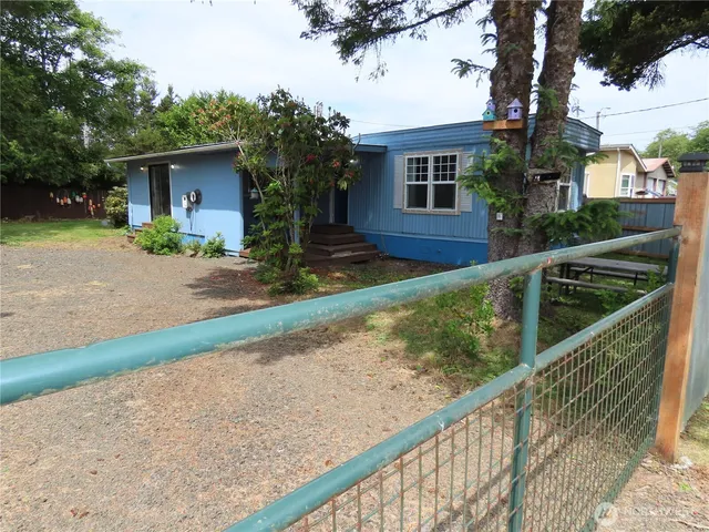a view of backyard with wooden fence