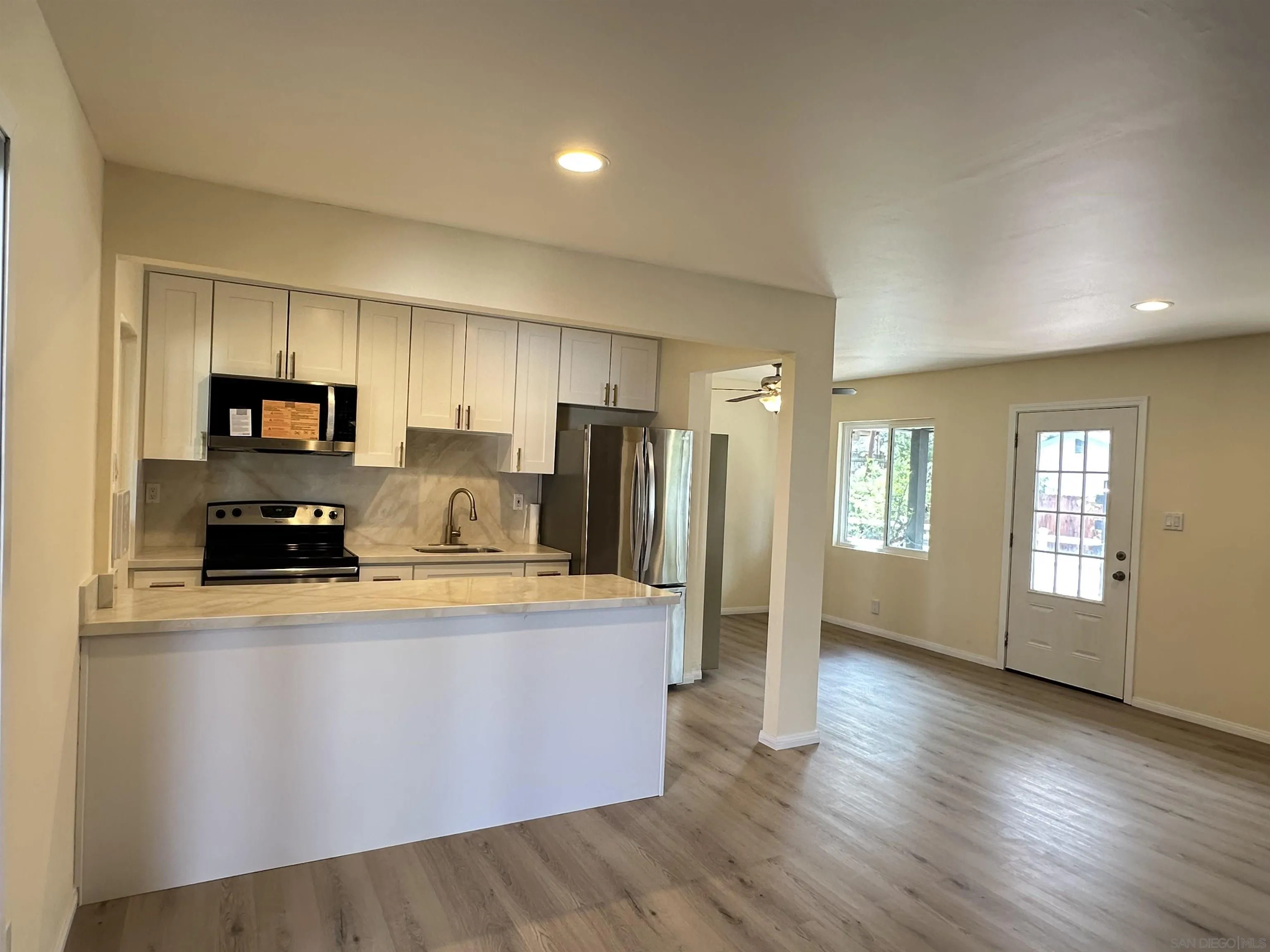2441 Gladiola Drive Campo, CA 91906 - Photo 3 of 17 a large kitchen with stainless steel appliances granite countertop a refrigerator a stove top oven a sink dishwasher and white countertops with wooden floor