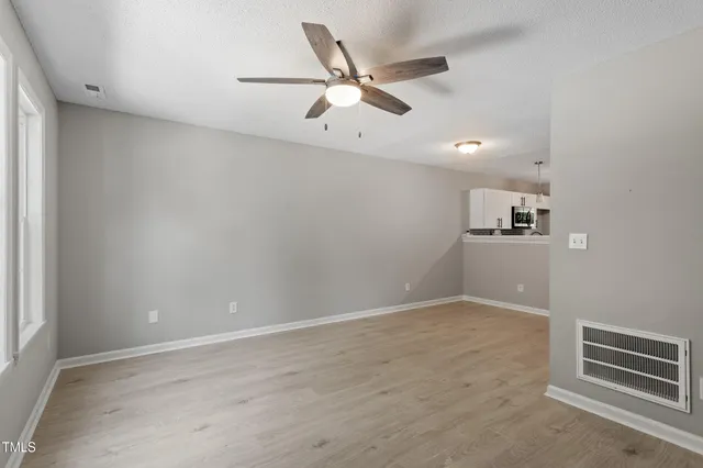 an empty room with closet and windows