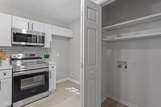 a kitchen with white cabinets and stainless steel appliances
