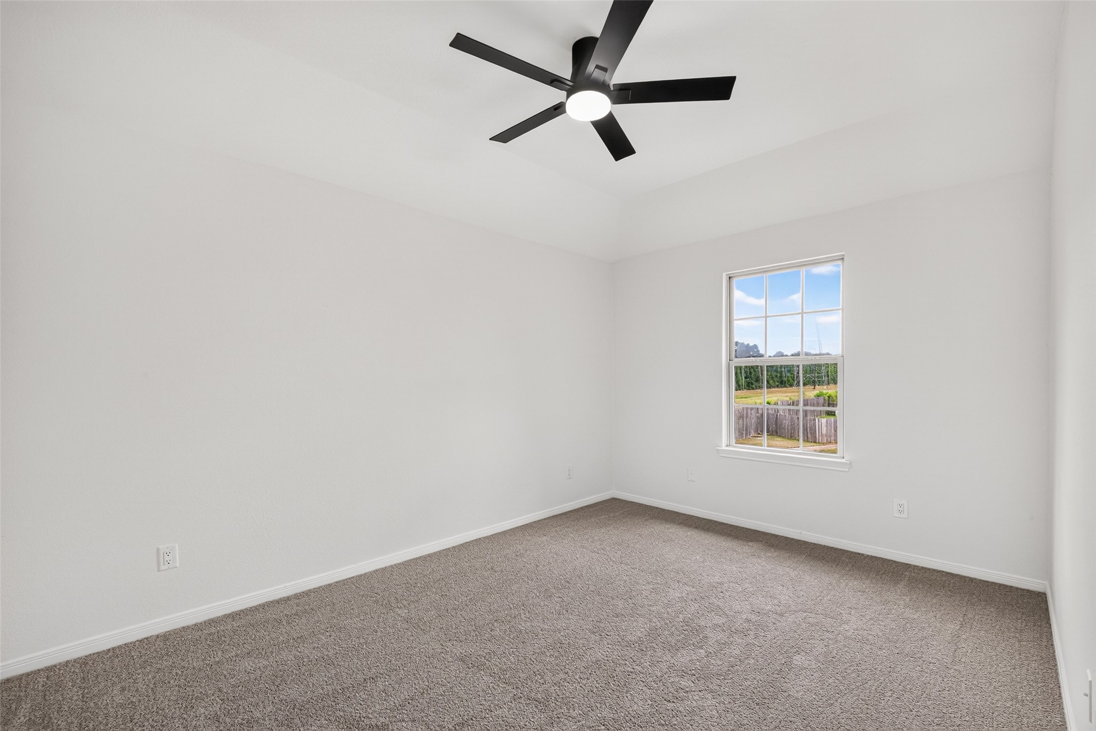 22623 Ebbets Field Drive Spring, TX 77389 - Photo 34 of 43 Secondary Bedroom #2: Soak in the quiet views from the large picture window in this bright, light-filled bedroom retreat. Designed for total comfort, it pairs plush carpet underfoot with a sleek ceiling fan overhead—creating a restful, calming space you’ll love coming home to every single day