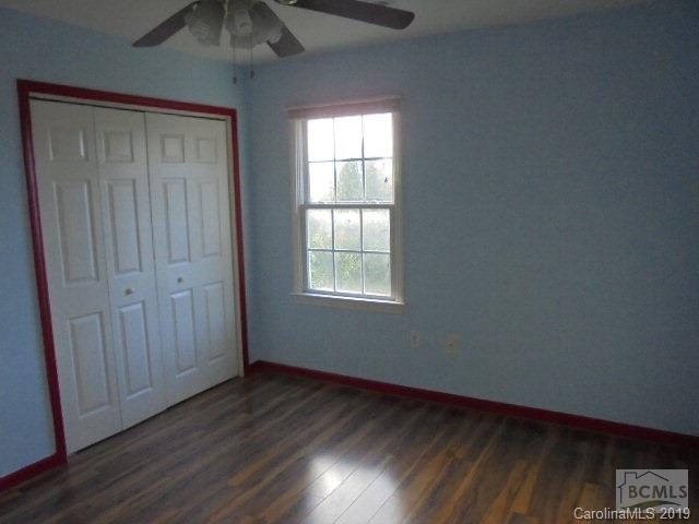 301 General Griffith Circle Rutherfordton, NC 28139 - Photo 5 of 17 an empty room with wooden floor and windows with curtains