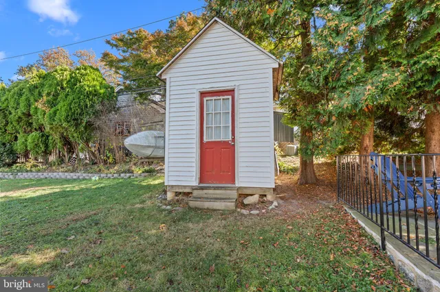 a view of backyard of house with wooden deck and outdoor seating