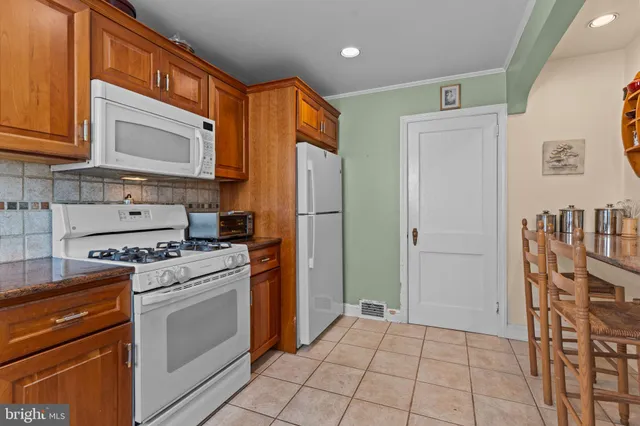 a kitchen with stainless steel appliances granite countertop a refrigerator and a stove top oven