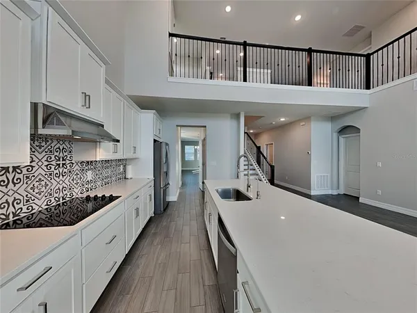 a kitchen with kitchen island granite countertop a large counter and stainless steel appliances
