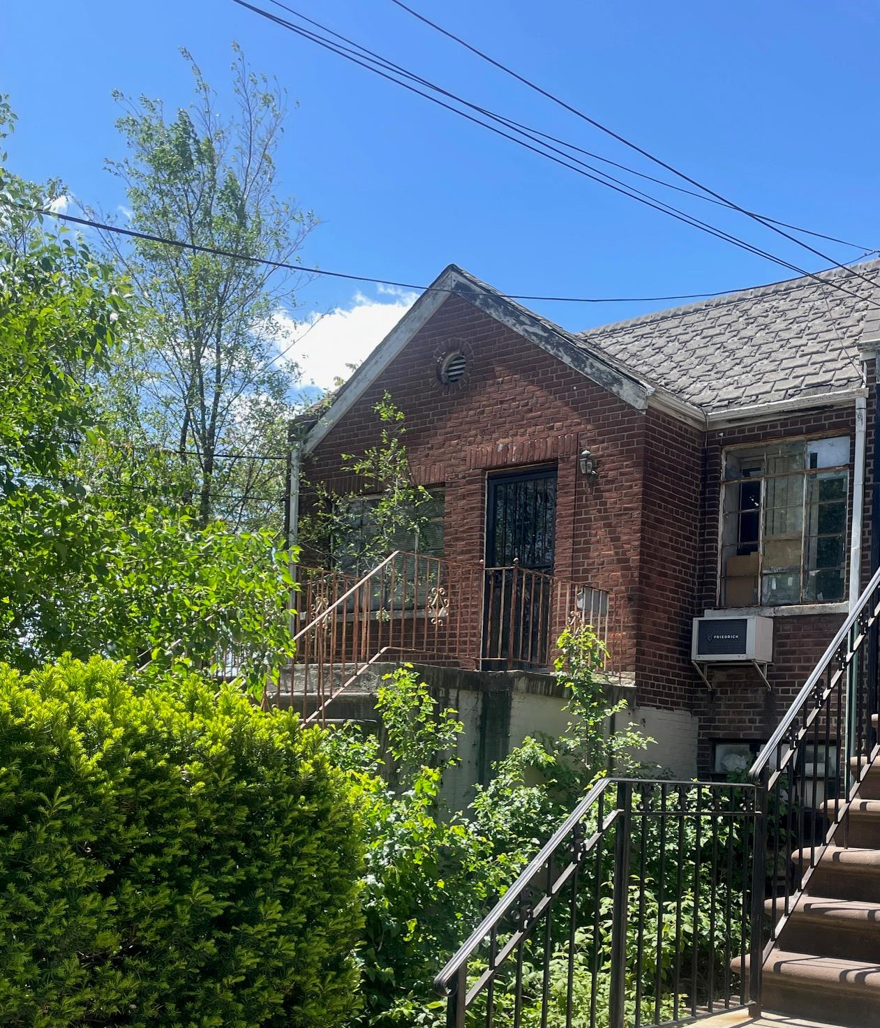 View of front of house with stairway and brick siding