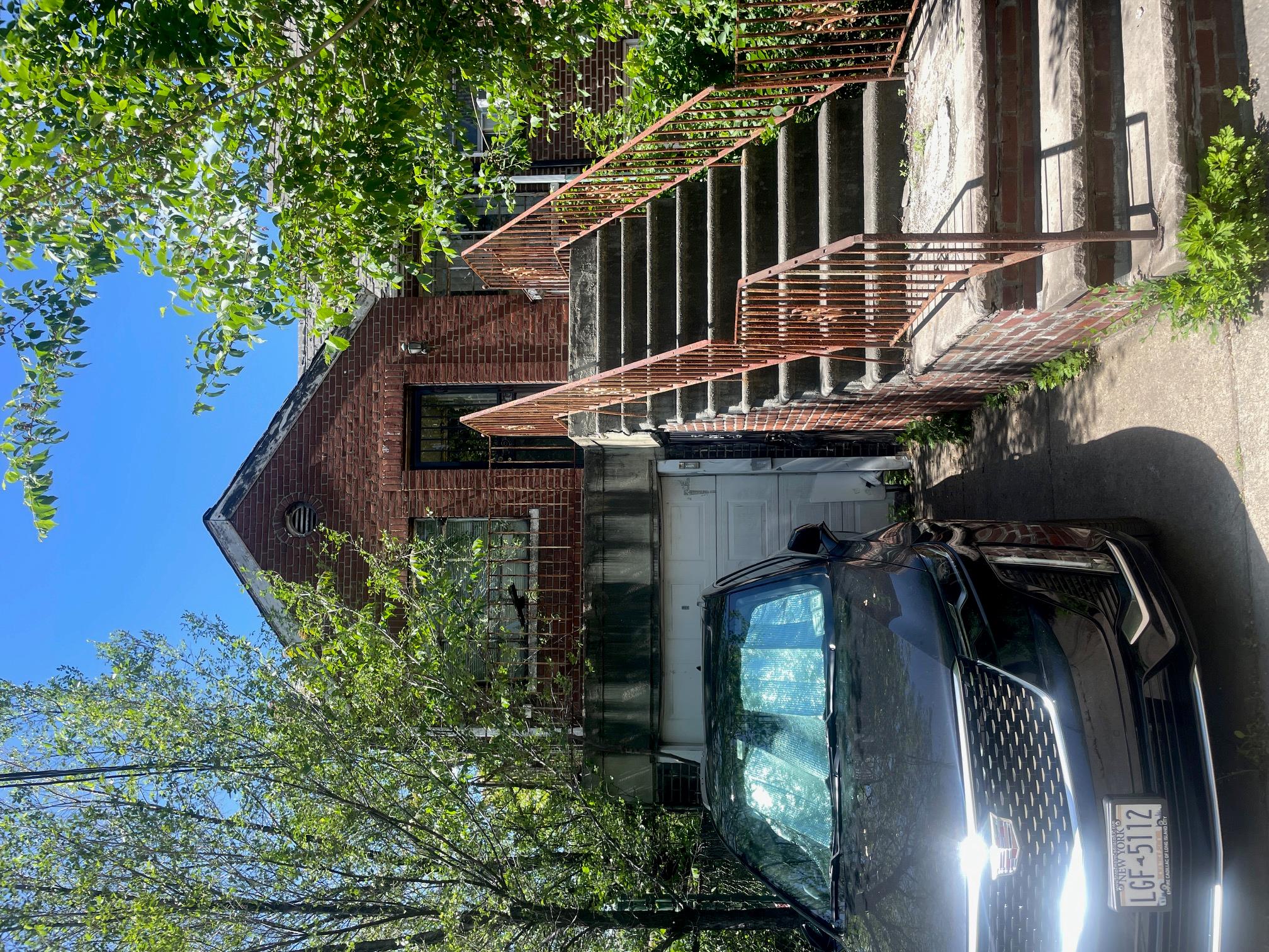 50-54 39th Place Queens, NY 11104 - Photo 2 of 3 View of front facade with brick siding, an attached garage, and stairway