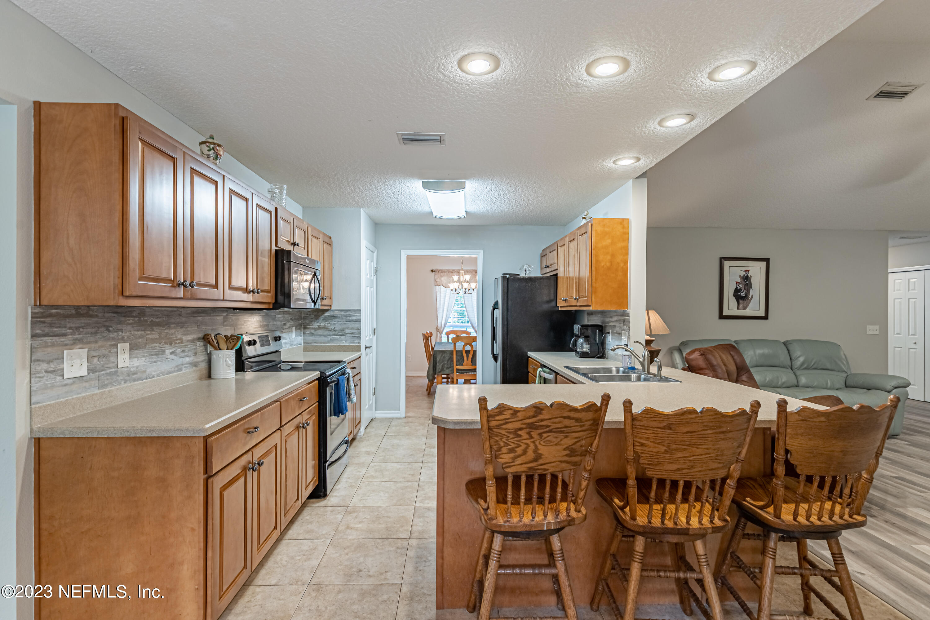 1193 Marlee Road St. Johns, FL 32259 - Photo 16 of 63 a large kitchen with kitchen island granite countertop a stove a sink a dining table and chairs