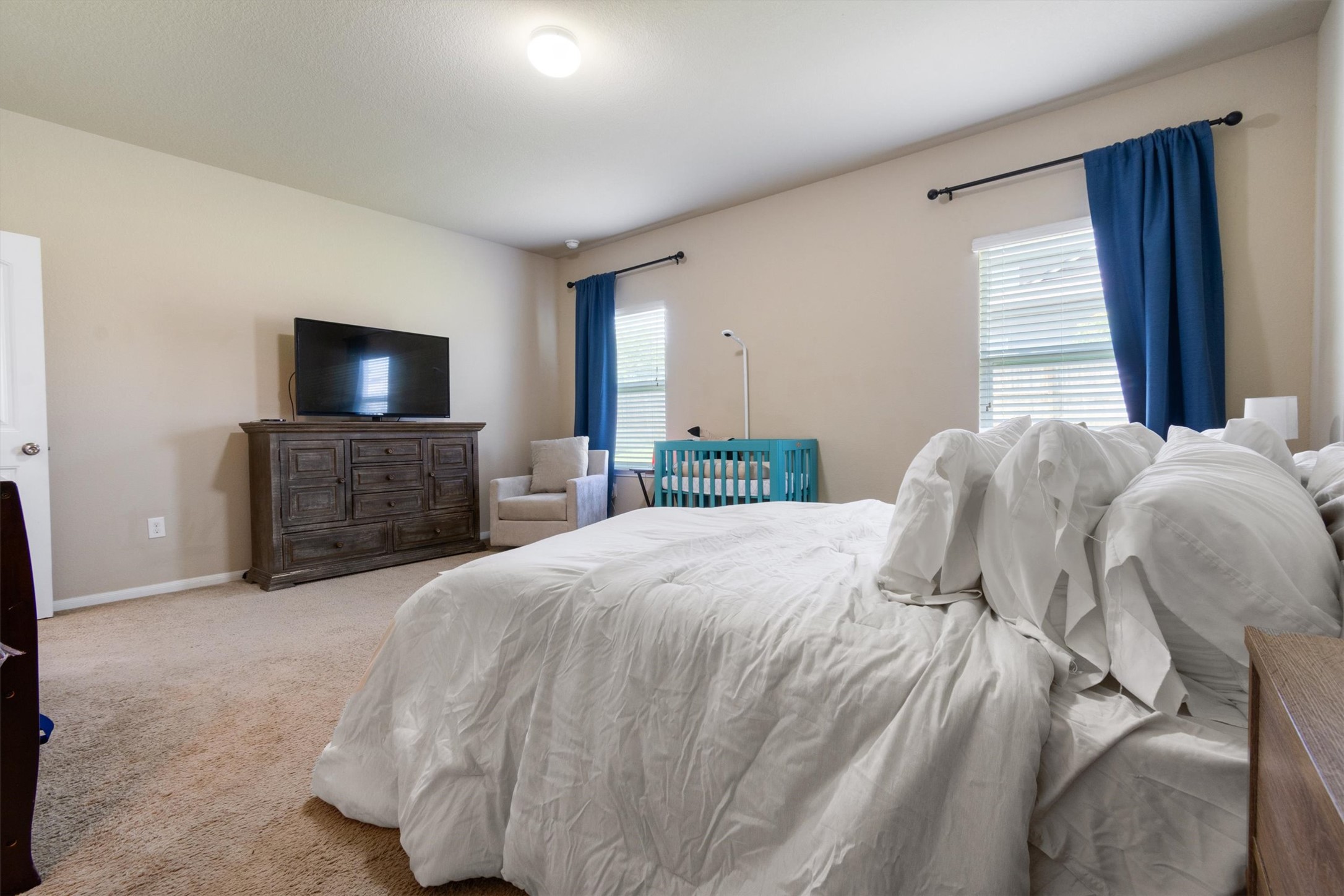 11620 Carbrook Road Manor, TX 78653 - Photo 23 of 40 a bedroom with a bed and a flat screen tv