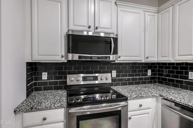a kitchen with stainless steel appliances granite countertop a stove and a microwave