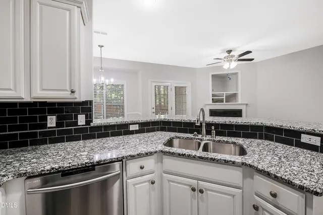 a kitchen with granite countertop a sink and cabinets