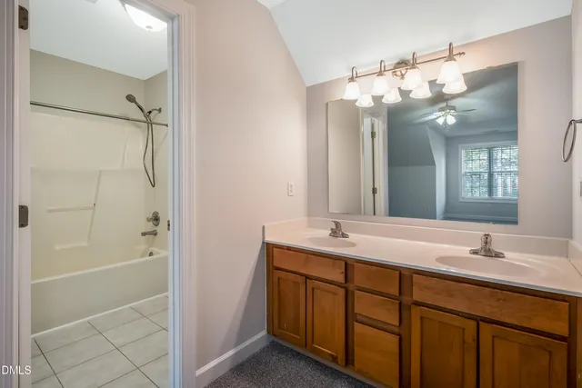 a bathroom with a double vanity sink mirror and shower