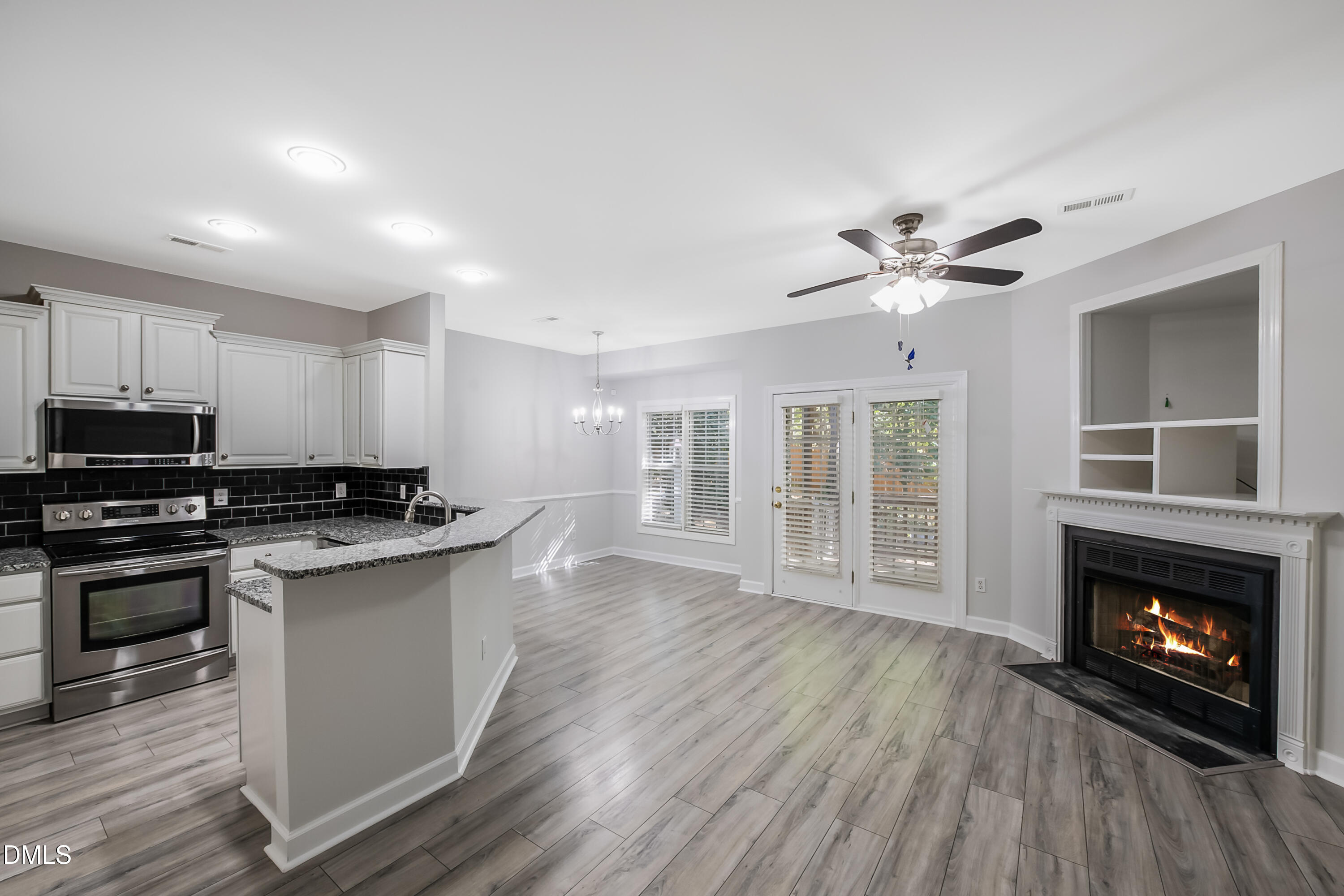 2639 Broad Oaks Place Raleigh, NC 27603 - Photo 8 of 24 a kitchen with stainless steel appliances granite countertop a stove top oven a sink dishwasher and a fireplace with wooden floor