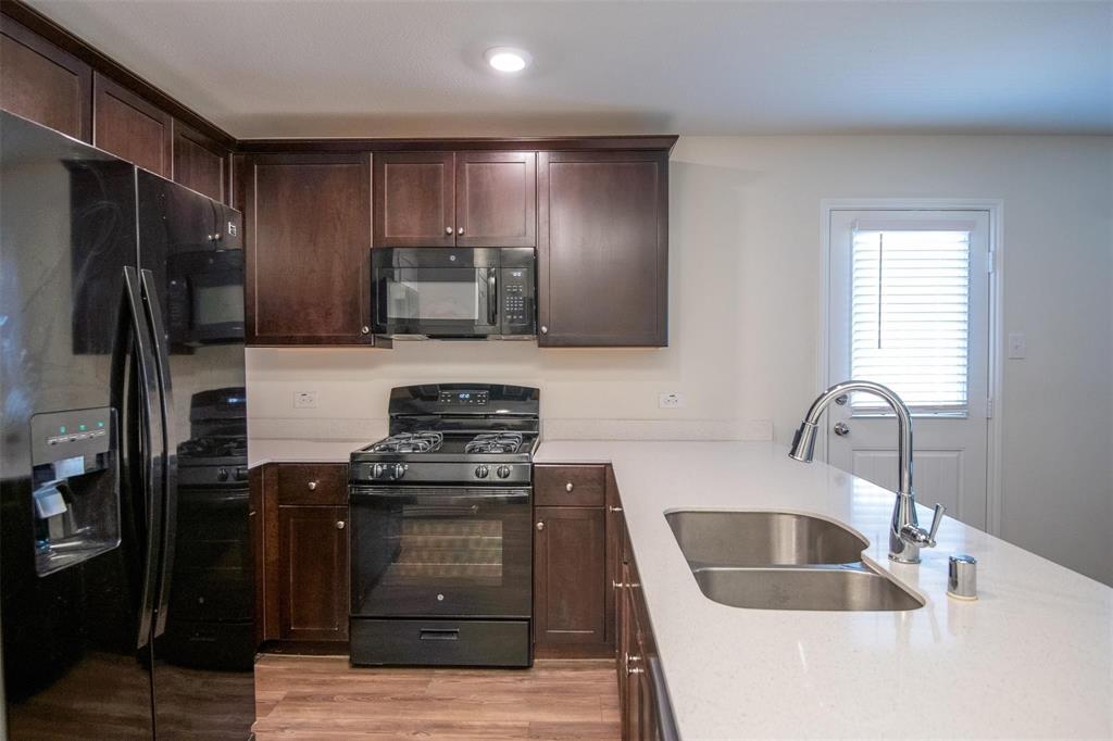 1215 Fairford Road Crandall, TX 75114 - Photo 4 of 17 a kitchen with granite countertop a refrigerator stove and sink