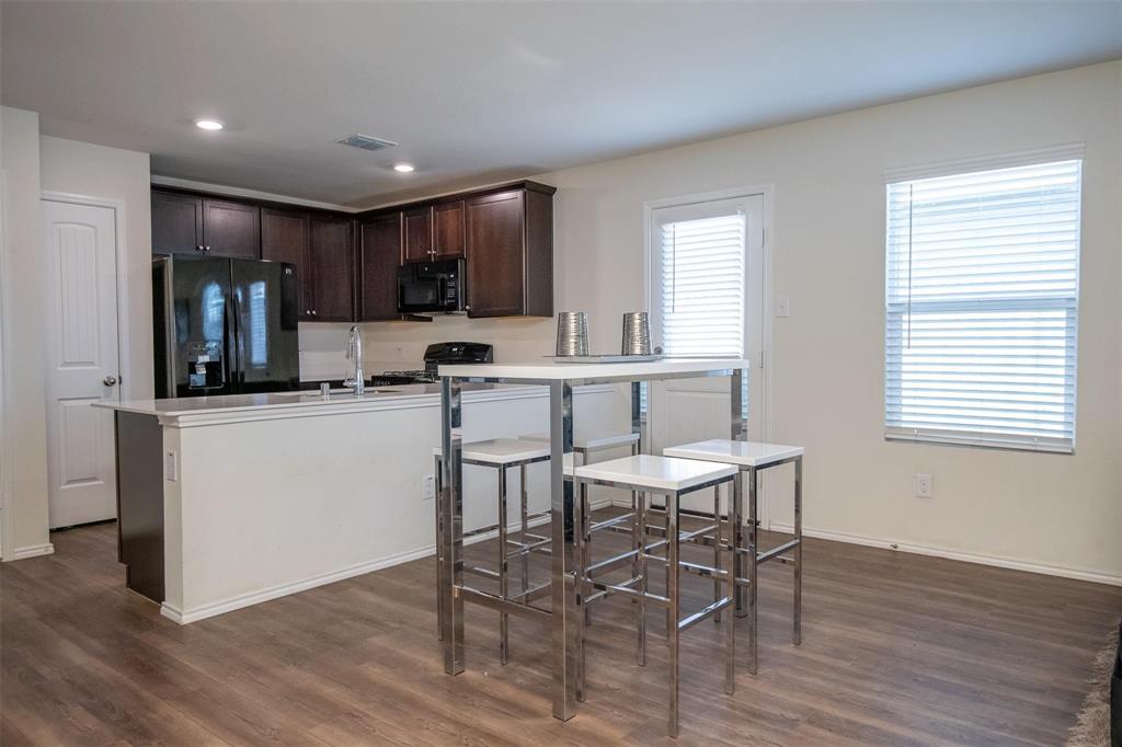 1215 Fairford Road Crandall, TX 75114 - Photo 5 of 17 a kitchen with a dining table chairs refrigerator and cabinets