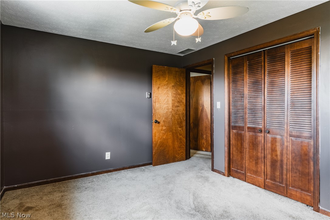 279 Spence Road Belpre, OH 45714 - Photo 21 of 40 Unfurnished bedroom with light carpet, a textured ceiling, a closet, and ceiling fan