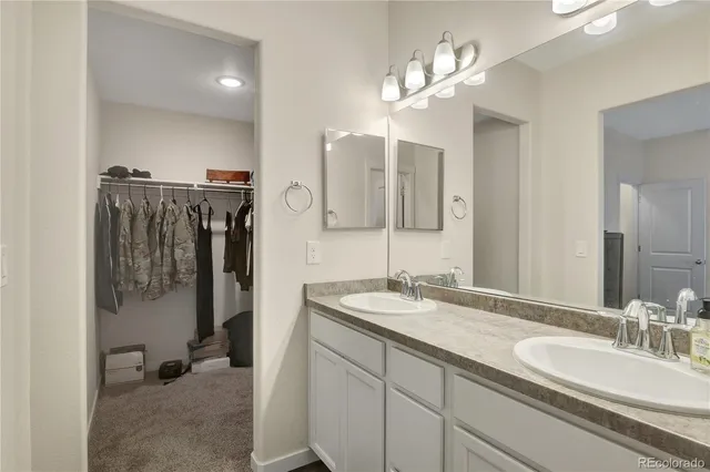 a spacious bathroom with a double vanity sink a mirror and shower