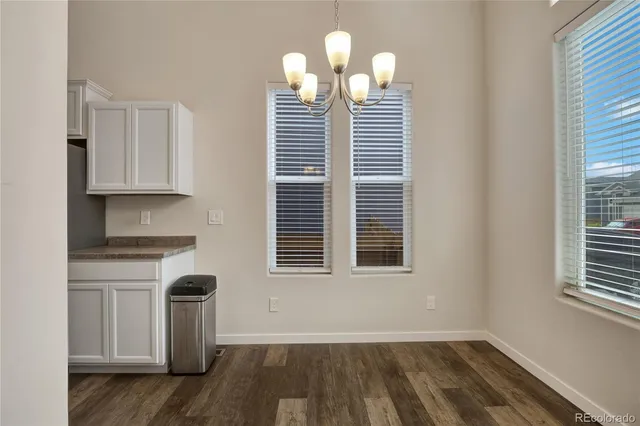 a view of a kitchen with wooden floor and a window