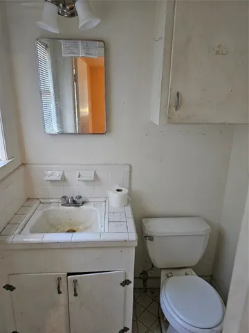a bathroom with a sink a toilet and mirror
