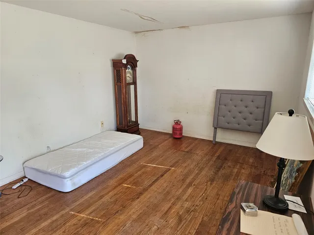 a view of a bedroom with furniture and wooden floor