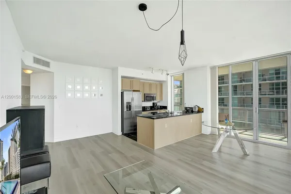 a living room with furniture large windows and wooden floor
