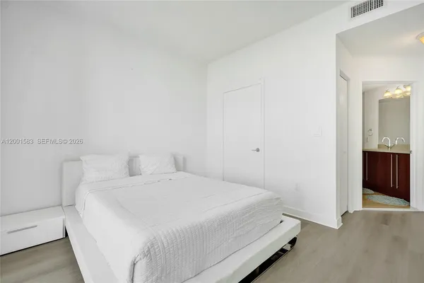 a bedroom with a bed and a large window