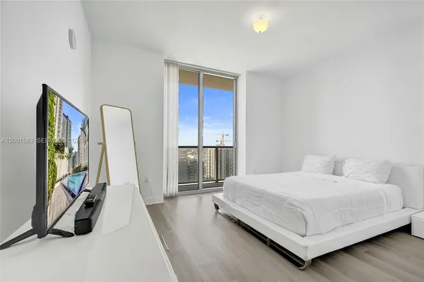 a bedroom with a bed and a flat screen tv