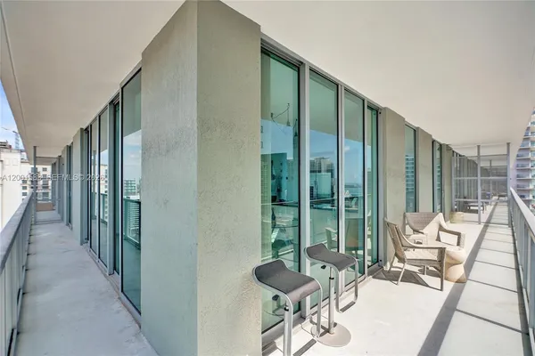 a view of a balcony with furniture and floor to ceiling window