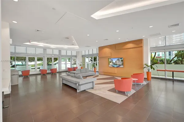 a living room with furniture and floor to ceiling windows