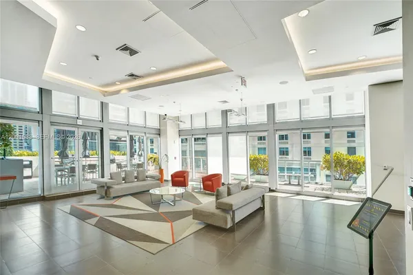 a view of a hall with the floor to ceiling windows and dining room