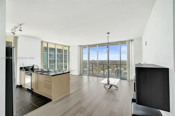 a kitchen with granite countertop a stove a sink a large window and living room view