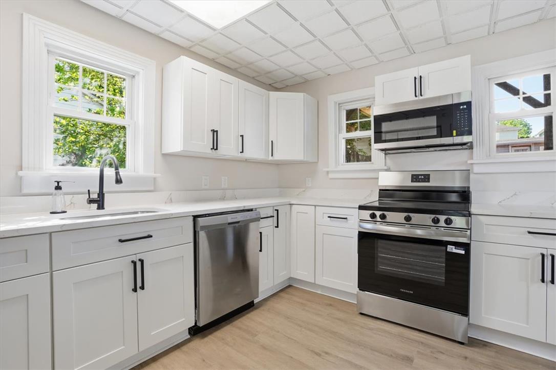 110 Messinger Street Bangor, PA 18013 - Photo 6 of 39 A well-lit kitchen with sleek white cabinetry and resilient wood flooring offers a functional culinary space.