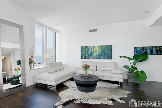 a living room with furniture and a potted plant