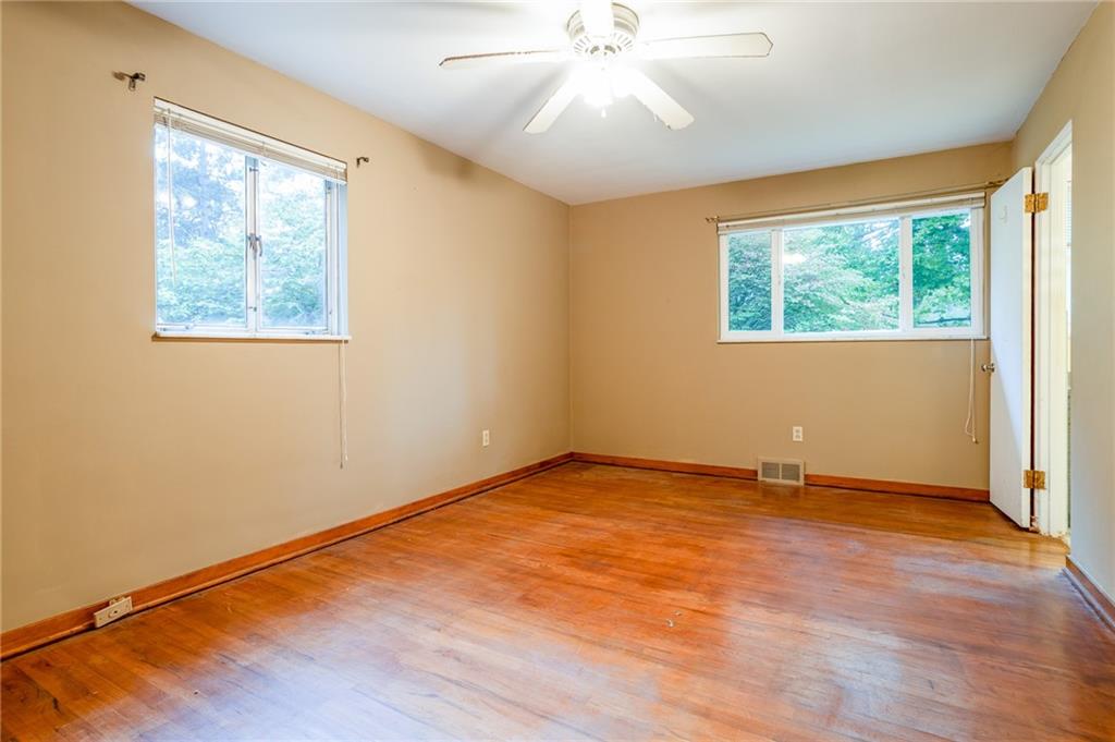 497 Ross Road Eighty Four, PA 15330 - Photo 22 of 35 an empty room with wooden floor chandelier fan and windows